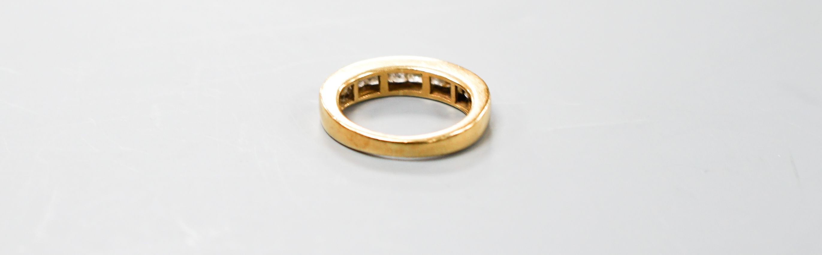 A modern 18ct gold and ten stone Princess cut diamond set half eternity ring, size I, gross 5.4 grams.